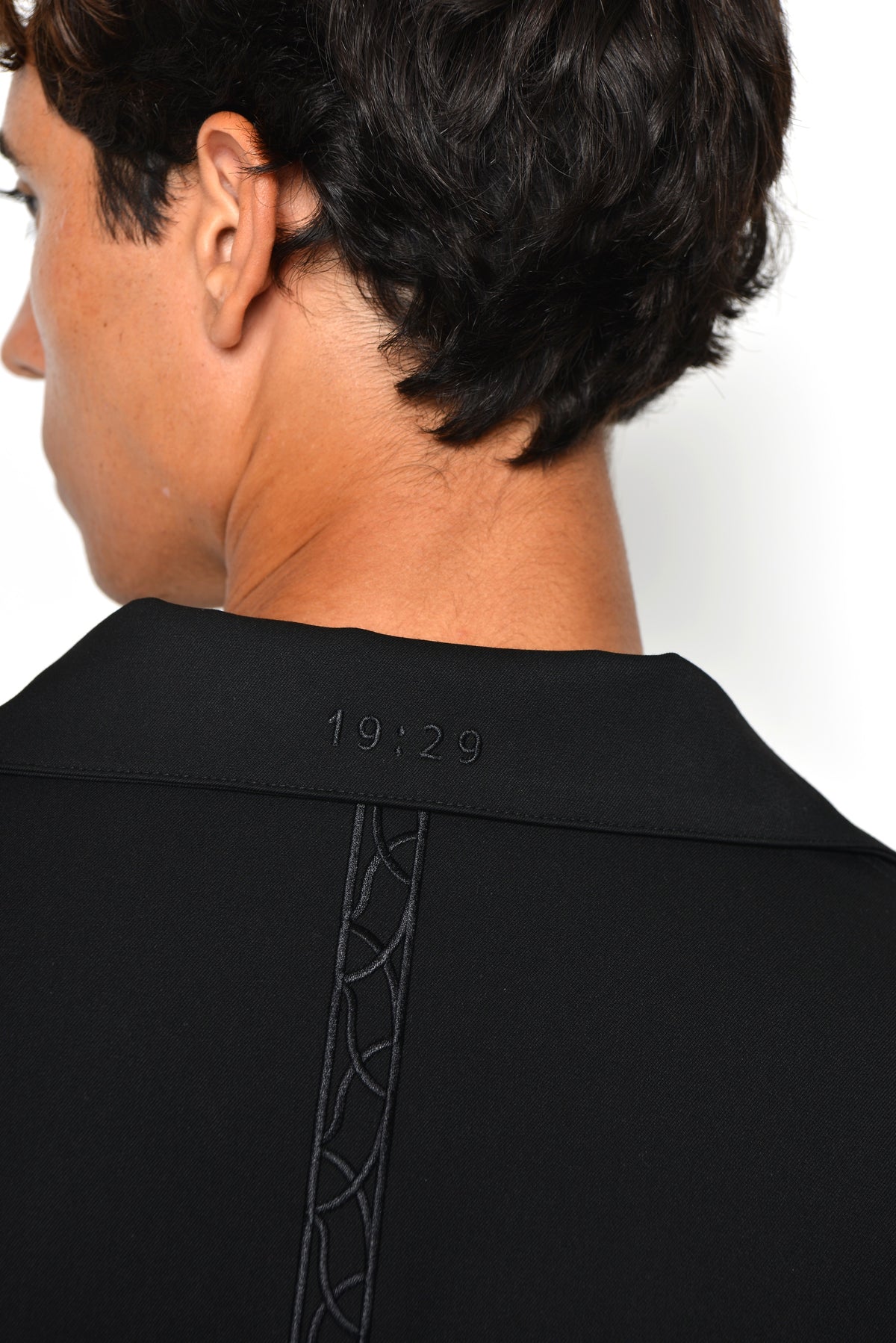 Back of the Tailored Collared Jacket: 19:29 embroidered below the collar and a tonal embroidered band down the centre back